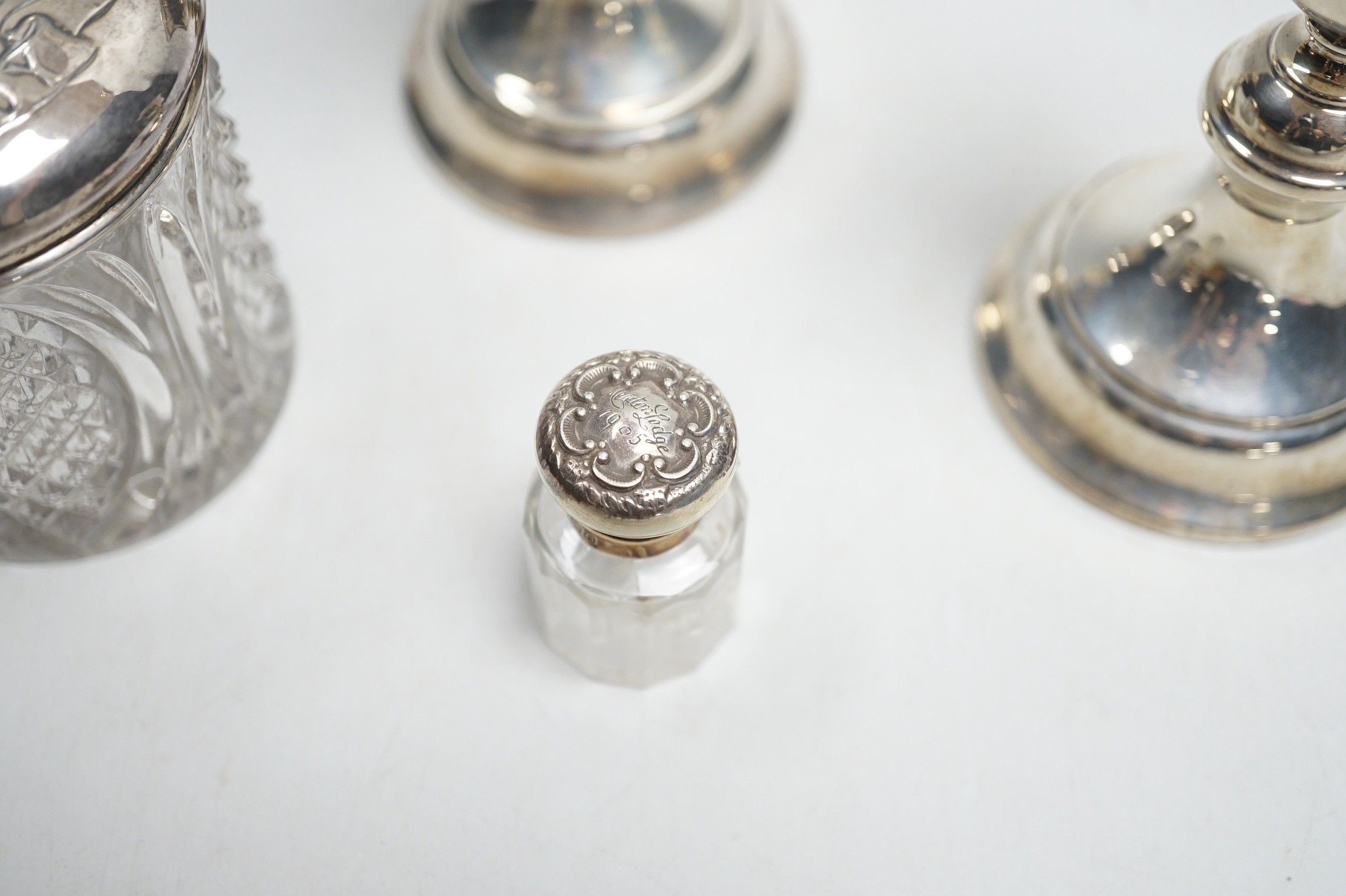 A pair of 1930's silver mounted dwarf candlesticks, 10cm, a silver mounted glass hair tidy and a scent bottle.